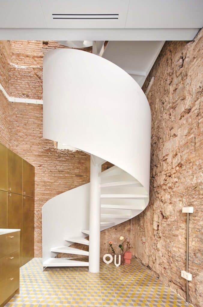 Die denkmalgeschützte Fassade kontrastiert die weiße Wendeltreppe