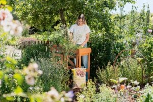Frau gärtnert an Pflanztisch im grünen Garten