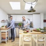 Zwei Männer bereiten Frühstück in moderner Küche zu