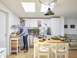 Zwei Männer bereiten Frühstück in moderner Küche zu