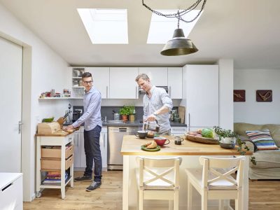 Zwei Männer bereiten Frühstück in moderner Küche zu